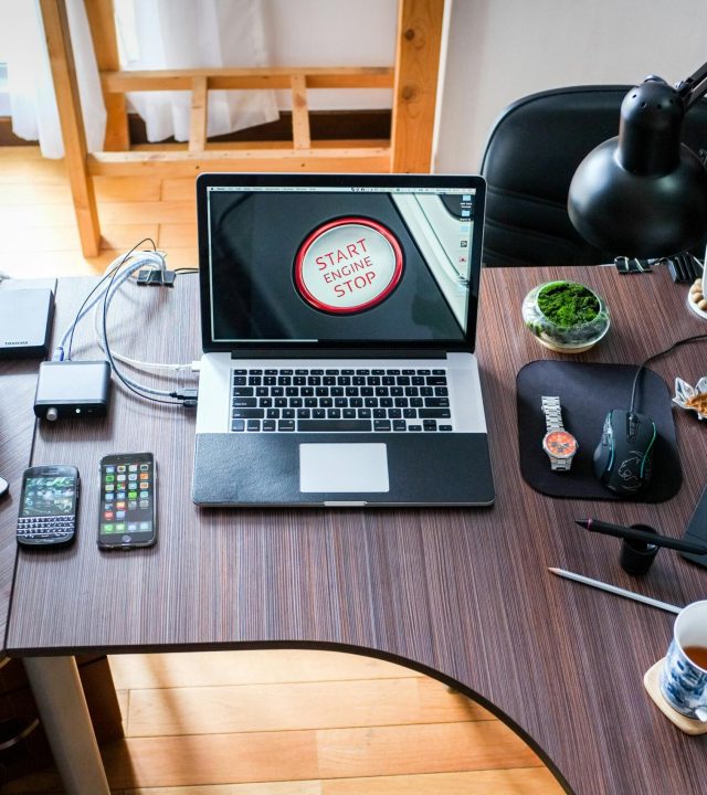 A contemporary office desk setup with laptops, gadgets, and accessories, creating a tech-savvy workplace.